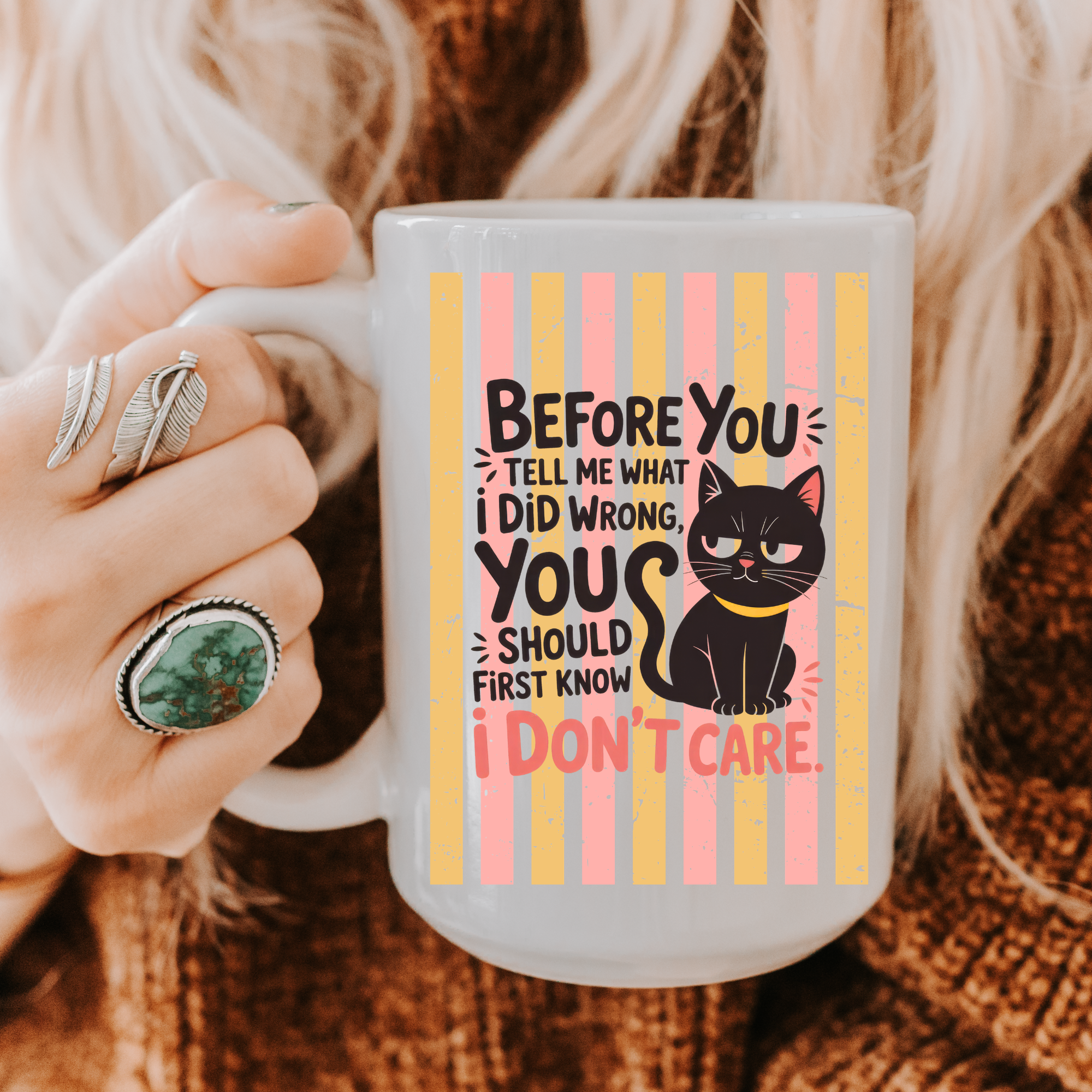 Person holding a 15oz mug with a cat illustration and text on a striped background