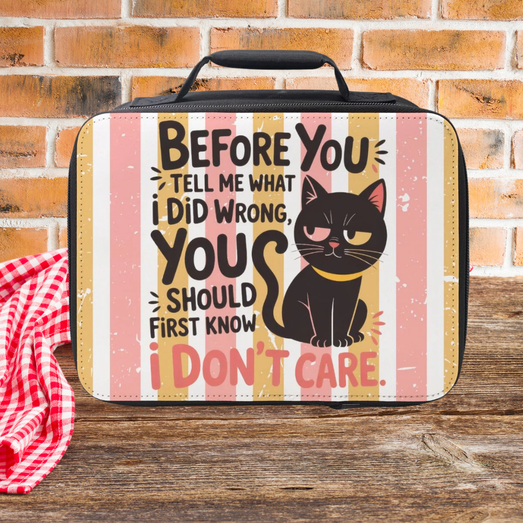 Lunch bag with a cat illustration and humorous text with a pink and yellow striped background on a wooden picnic table against a brick wall background