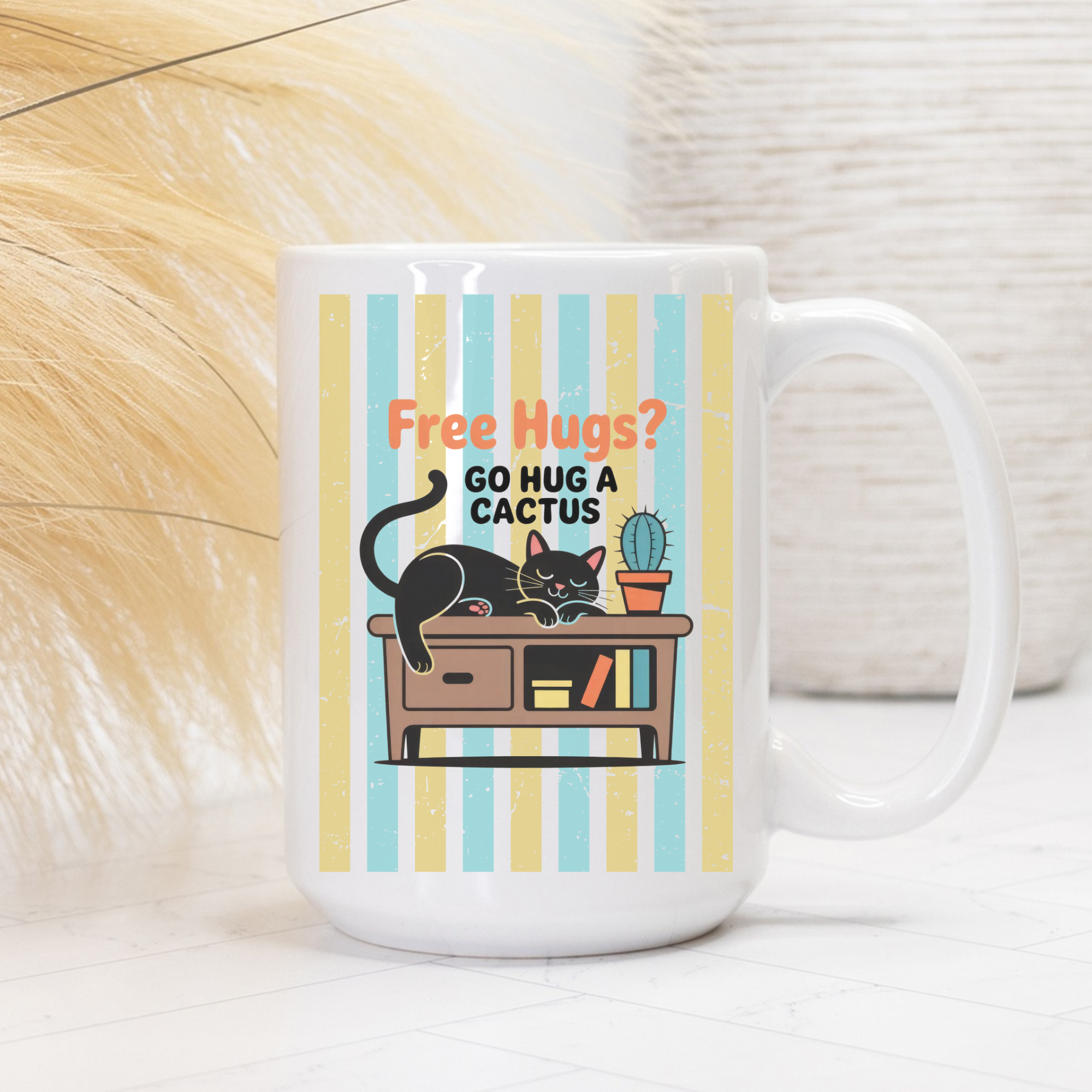 15oz Mug with a cat and cactus design and text 'Free Hugs? Go hug a cactus' on a striped background.