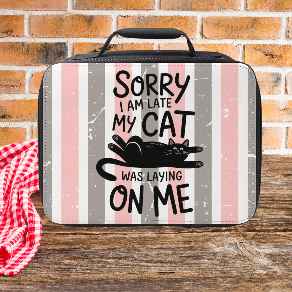 Lunch bag with a cat-themed design and text sitting on a wooden picnic table against a brick wall background