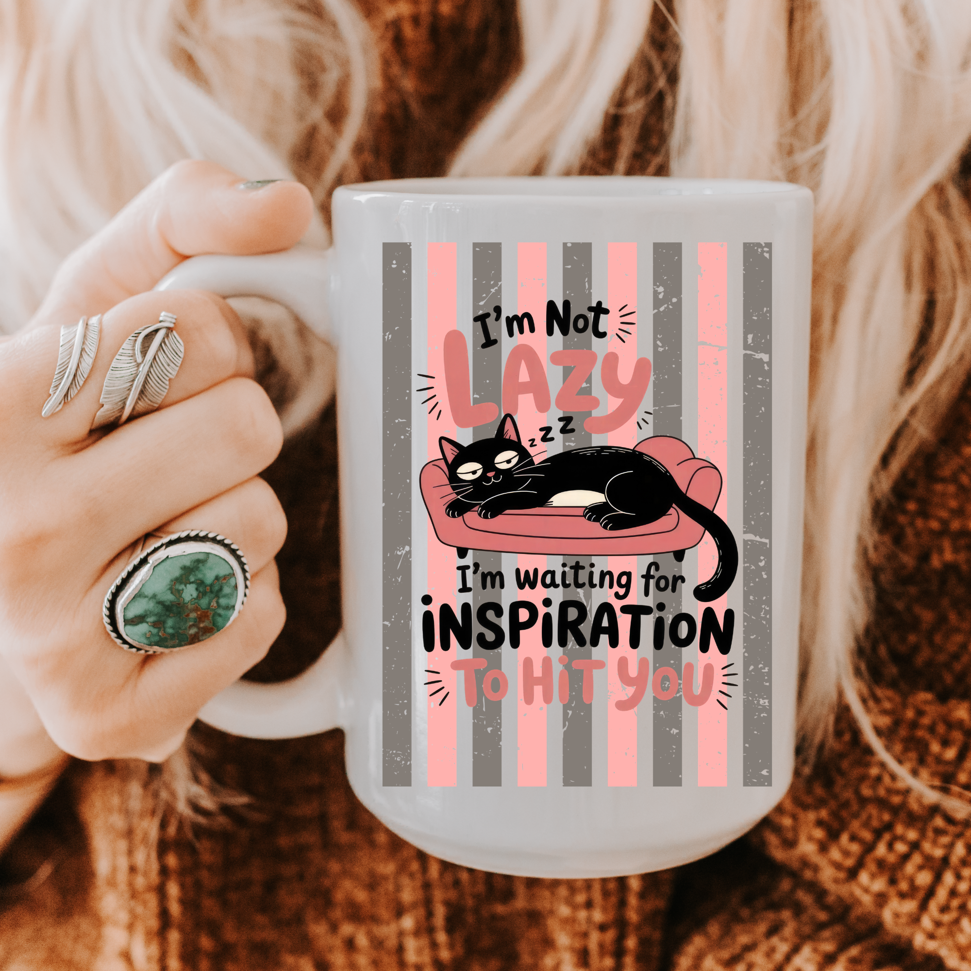 Person holding a 15oz mug with a cat design and text, wearing rings.