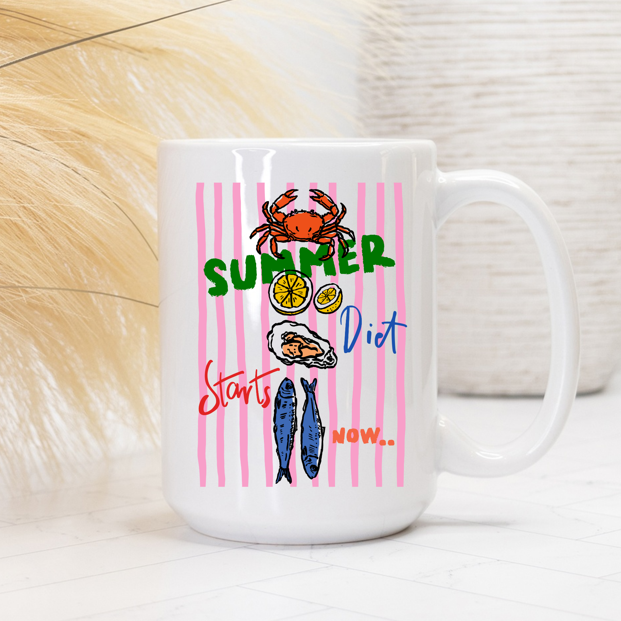 White 15oz. mug with summer-themed design featuring a crab, lemon, oyster, and fish on a pink striped background.