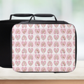 Black and pink patterned lunch bag on a white surface with a blurred background