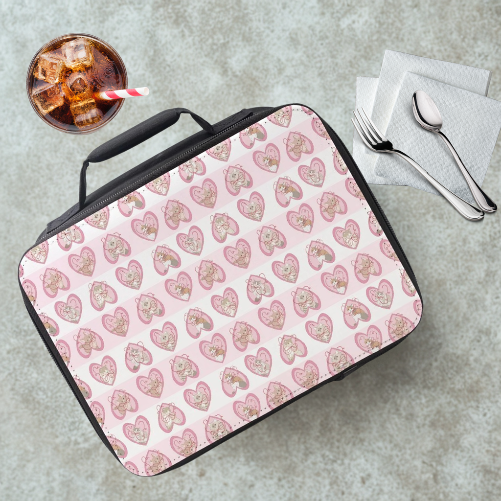 hand drawn cats in pink hearts patterned lunch bag on a cafeteria table with a drink and utensils.