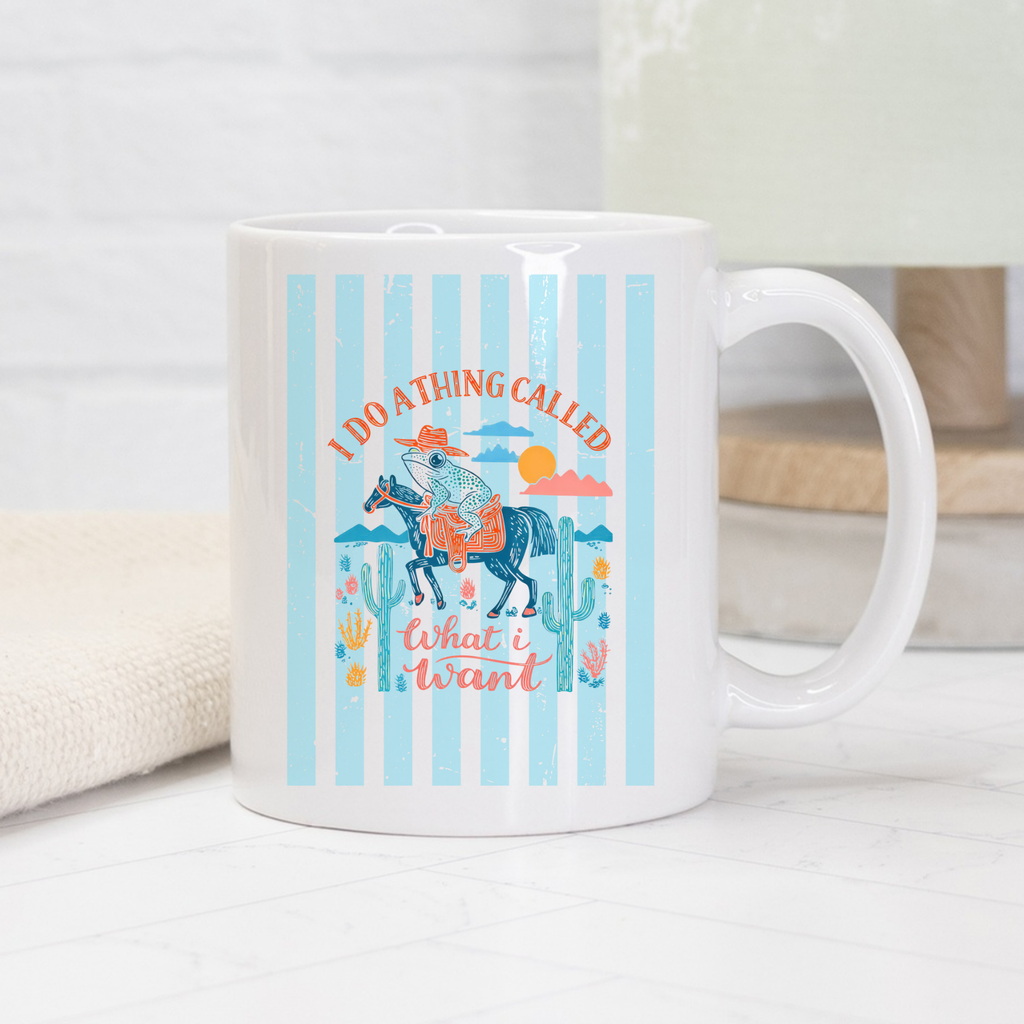 White 11oz mug with a colorful striped western cowboy frog design featuring a horse and text on a light background