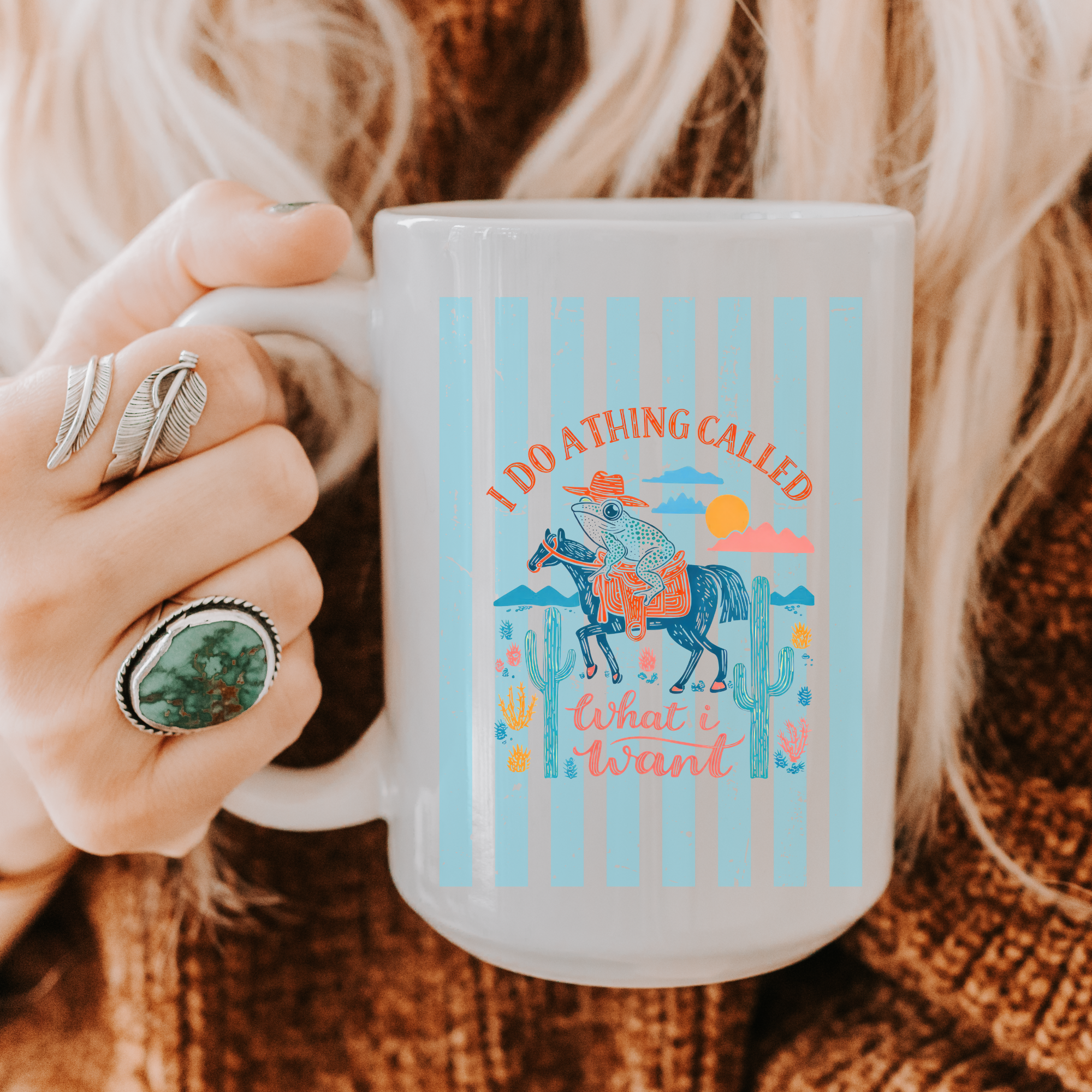 Person holding a 15oz. mug with a colorful design and text, wearing rings.
