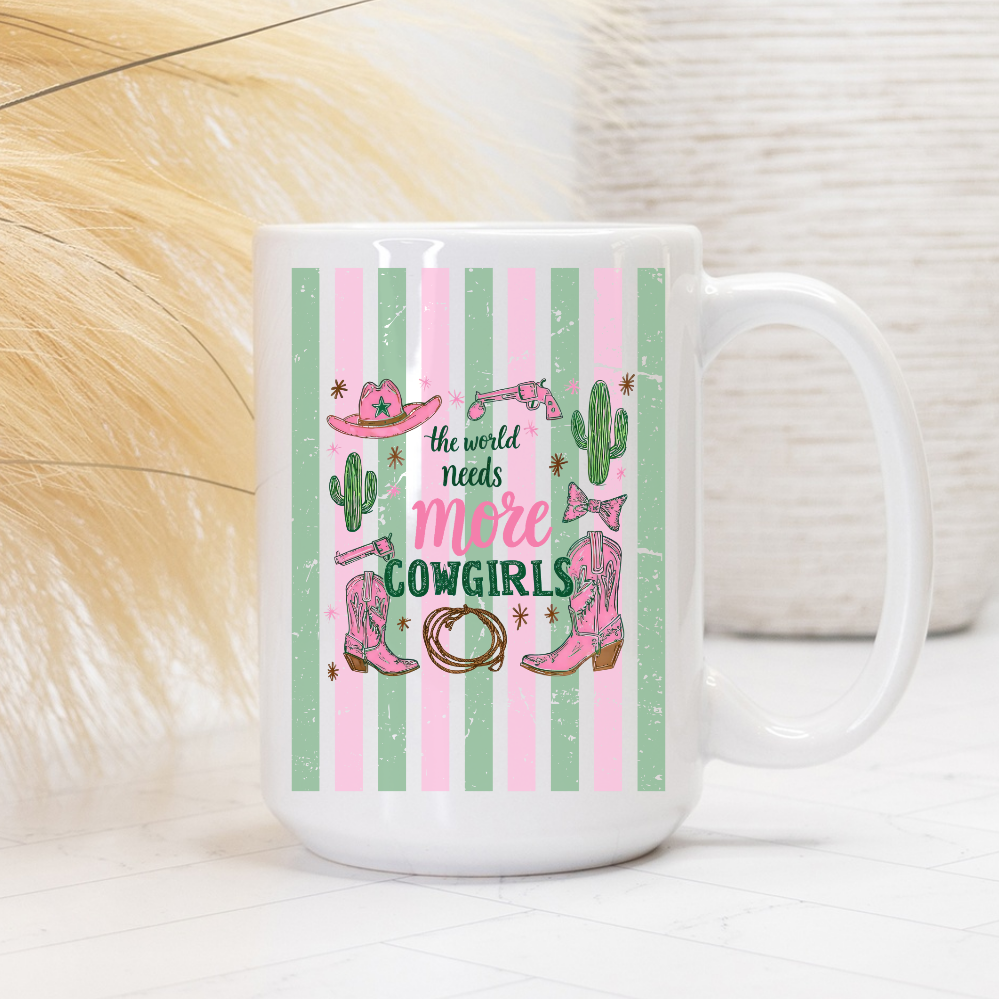 Mug with a pink and green striped cowgirl-themed design and text on a white background