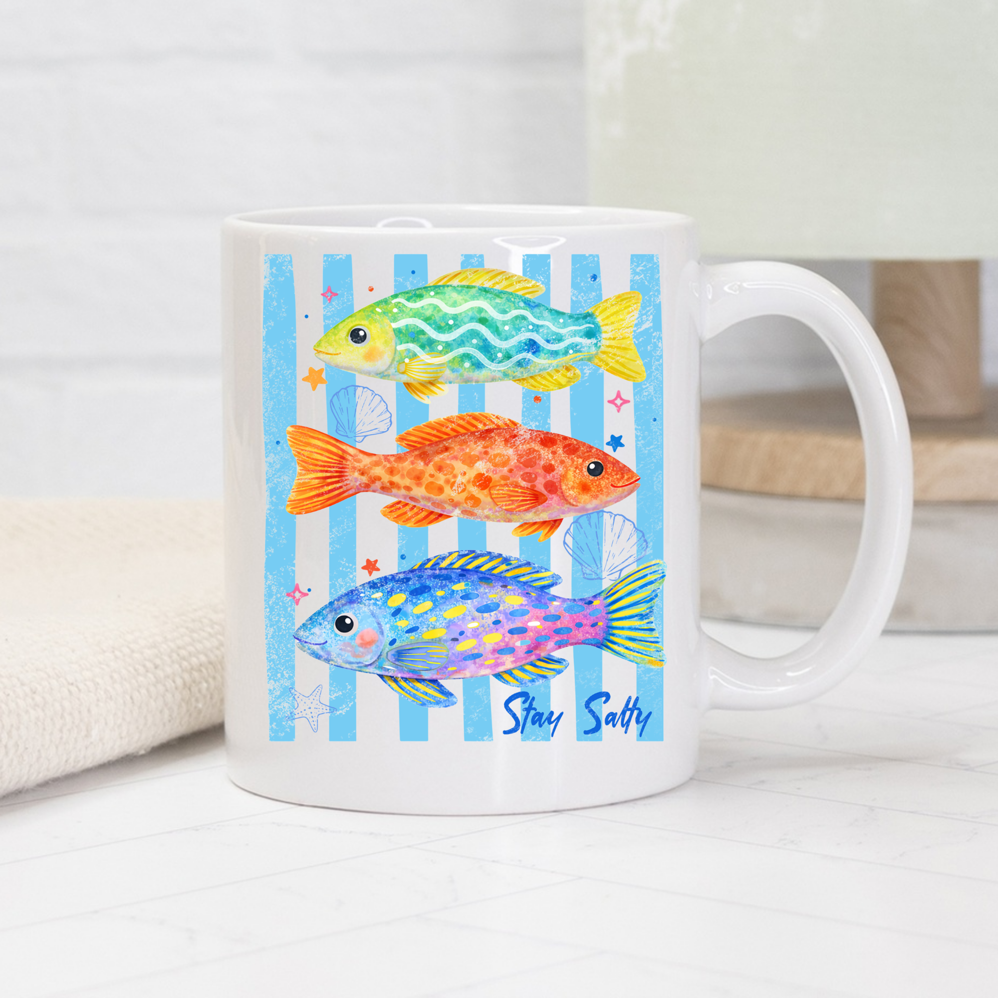White mug with colorful fish design and 'Stay Salty' text on a white background