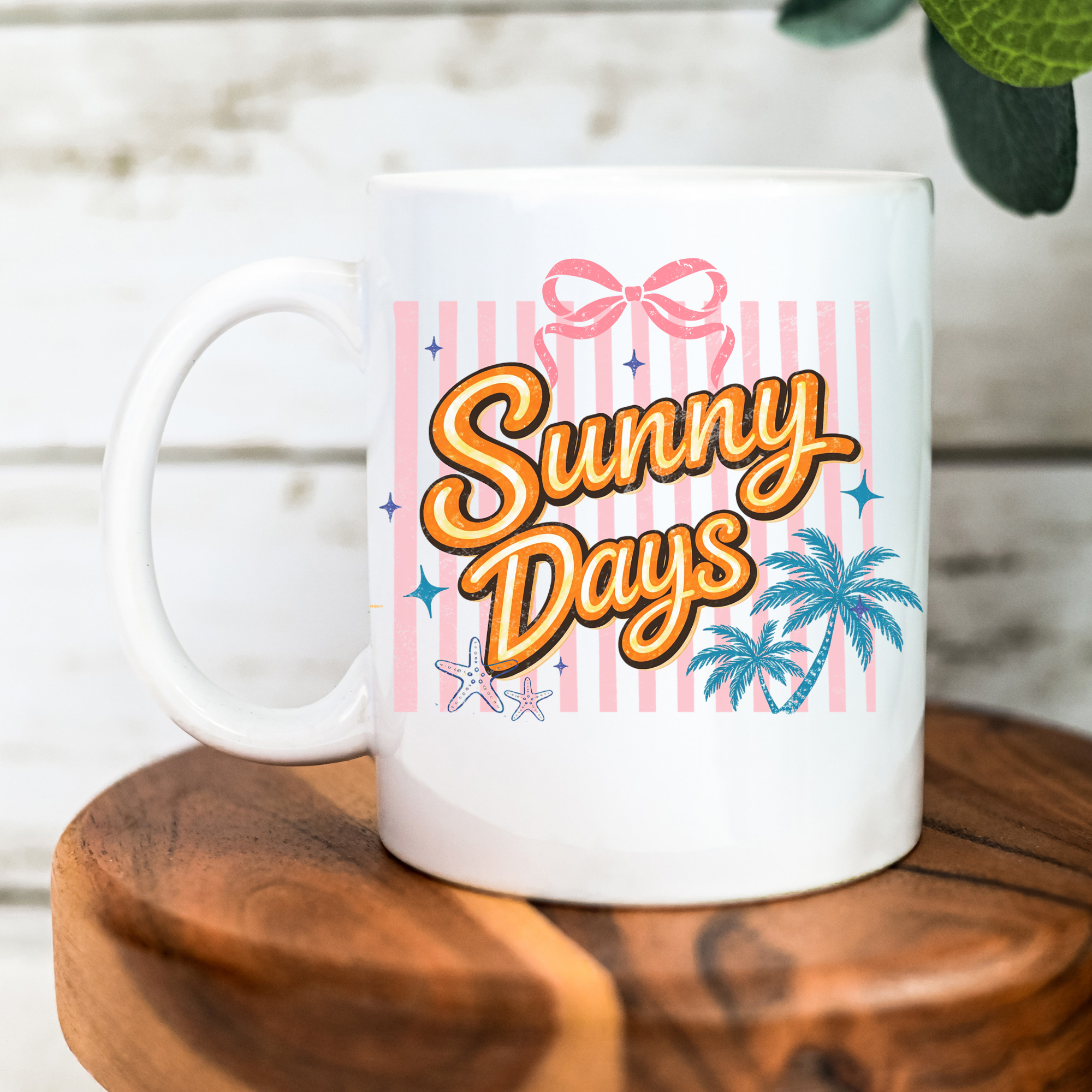 White 11oz. mug with 'Sunny Days' text and palm tree design on a wooden surface.