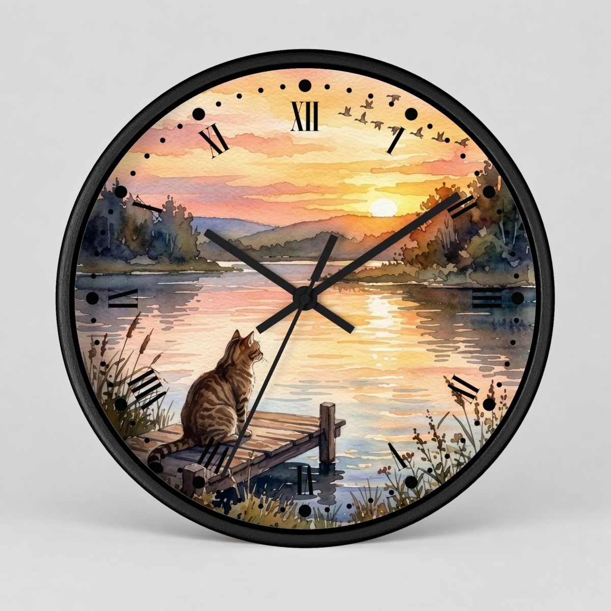 Round wall clock with a black frame and a scenic illustration of a cat sitting on a dock by a lake at sunset, with black Roman numerals and clock hands on a light gray background.