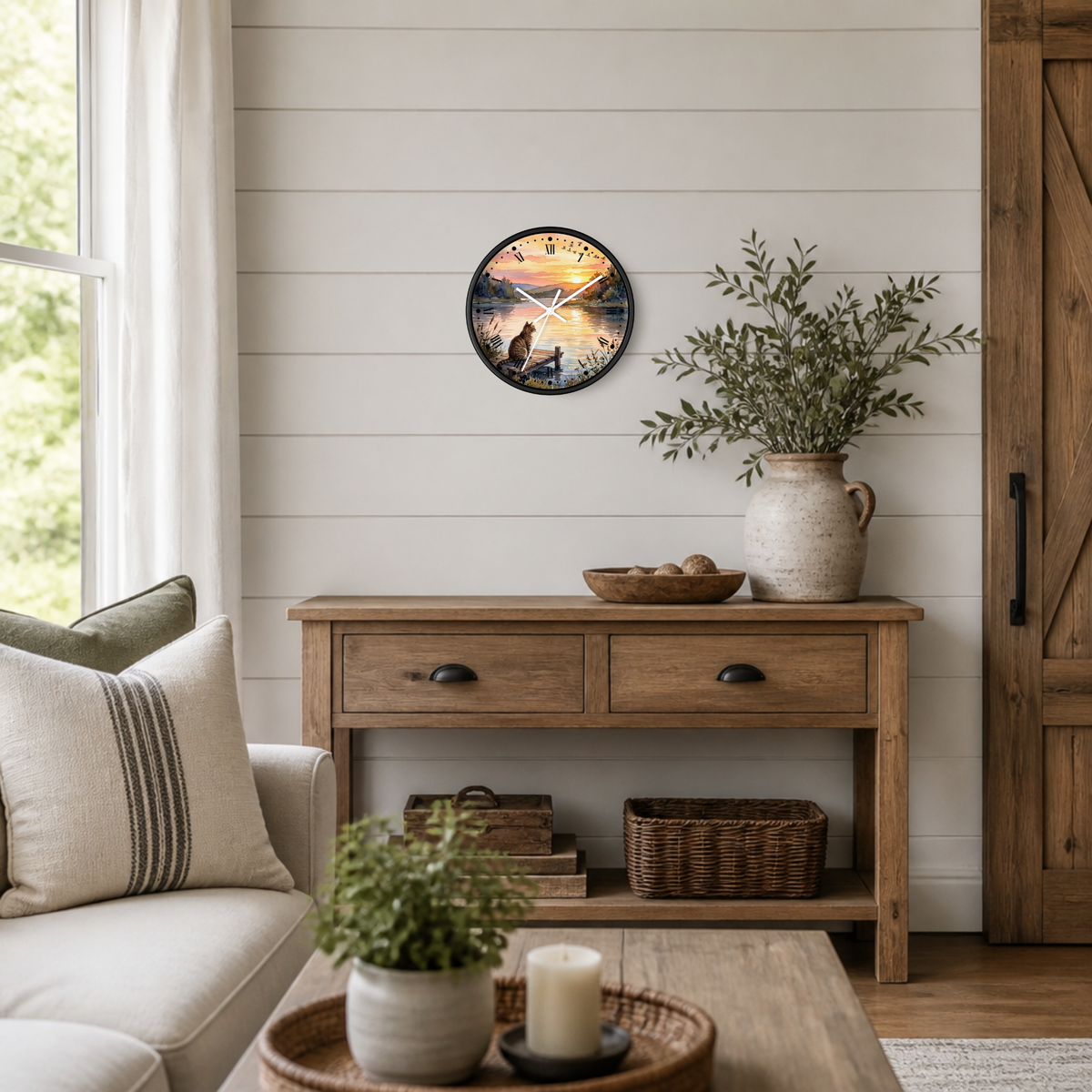 A round wall clock with a scenic sunset lake print hangs on a white shiplap wall above a rustic wooden console table in a bright, modern farmhouse living room.