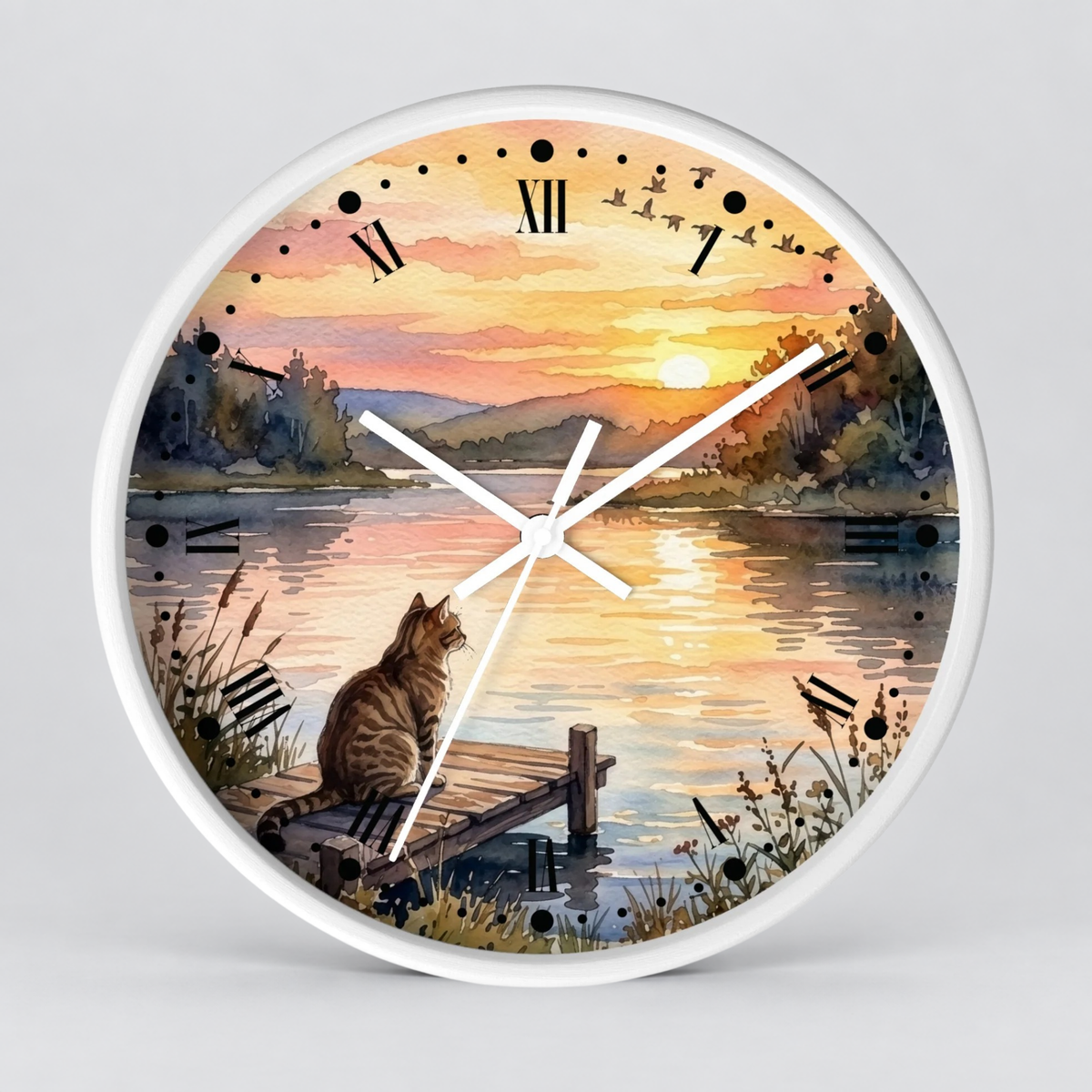 Round wall clock with a white frame and a scenic watercolor-style printed face showing a cat sitting on a dock by a lake at sunset, with black Roman numerals and white clock hands.