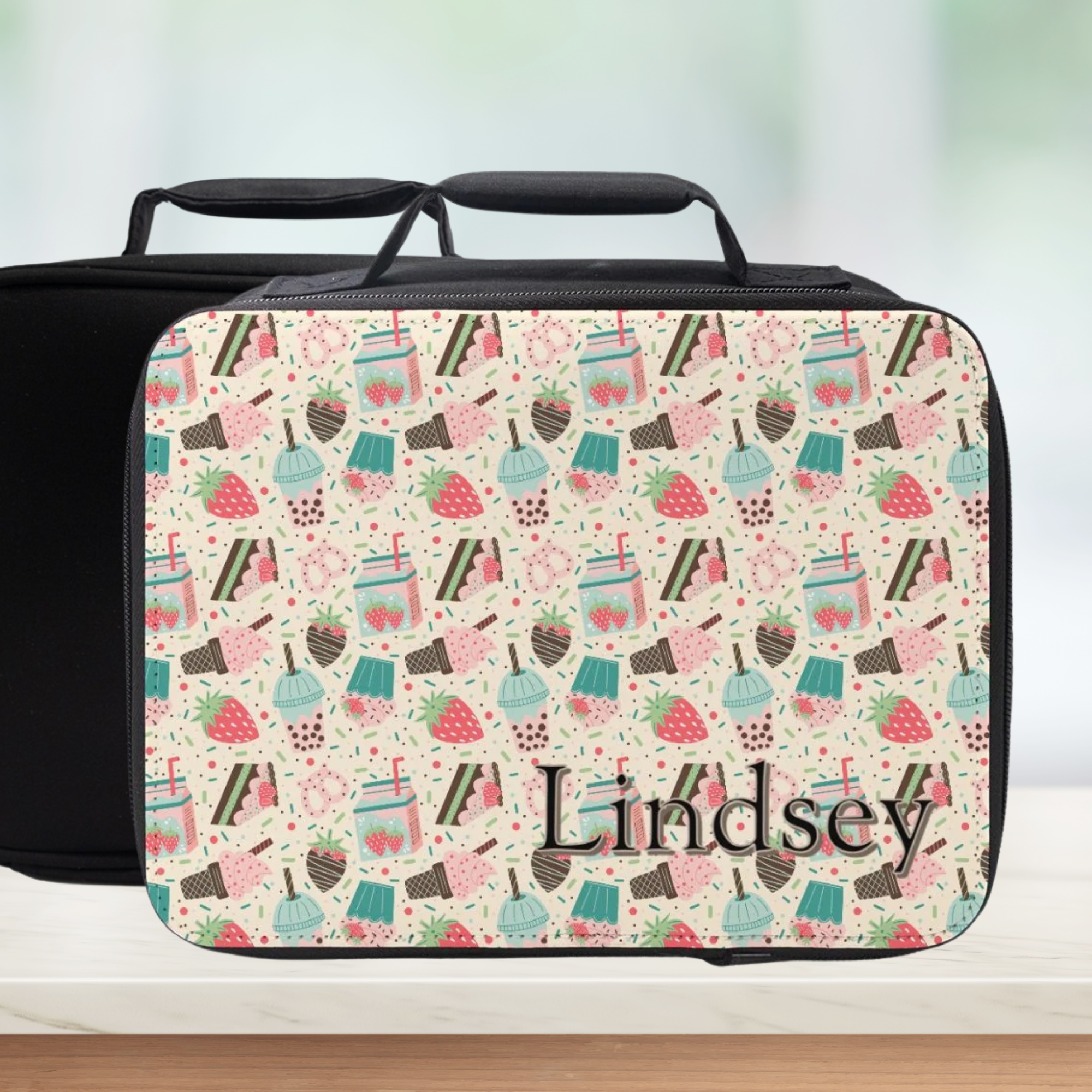black lunch bag with a cute desert theme and personalized with a name on a counter with a light background.