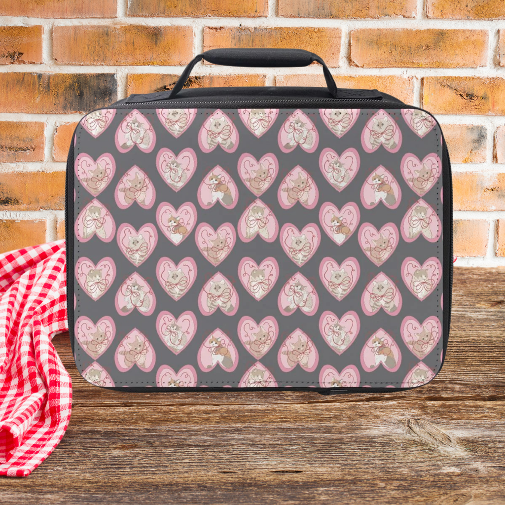 Lunch bag with hand drawn cats inside hearts pattern on a wooden picnic table and brick wall background