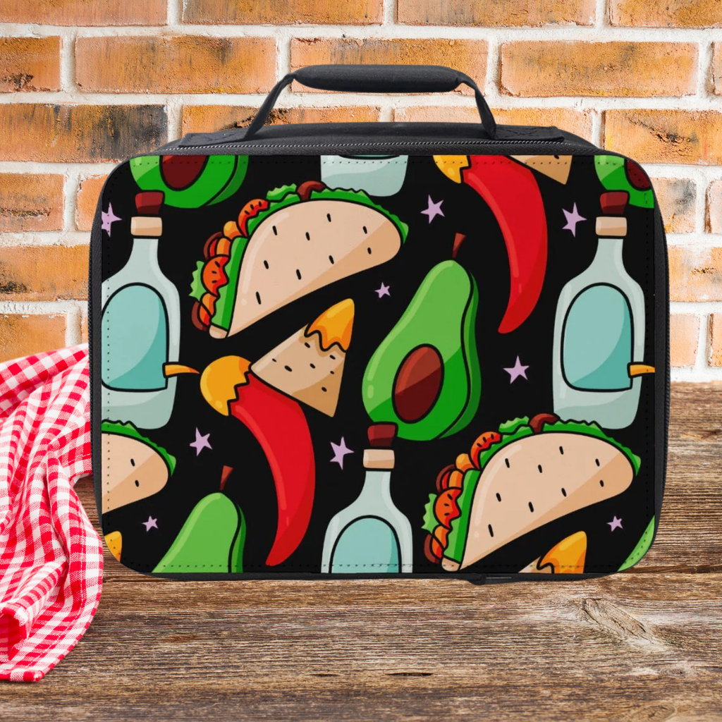  insulated lunch bag with colorful taco and avocado design on a wooden picnic table with a brick wall background