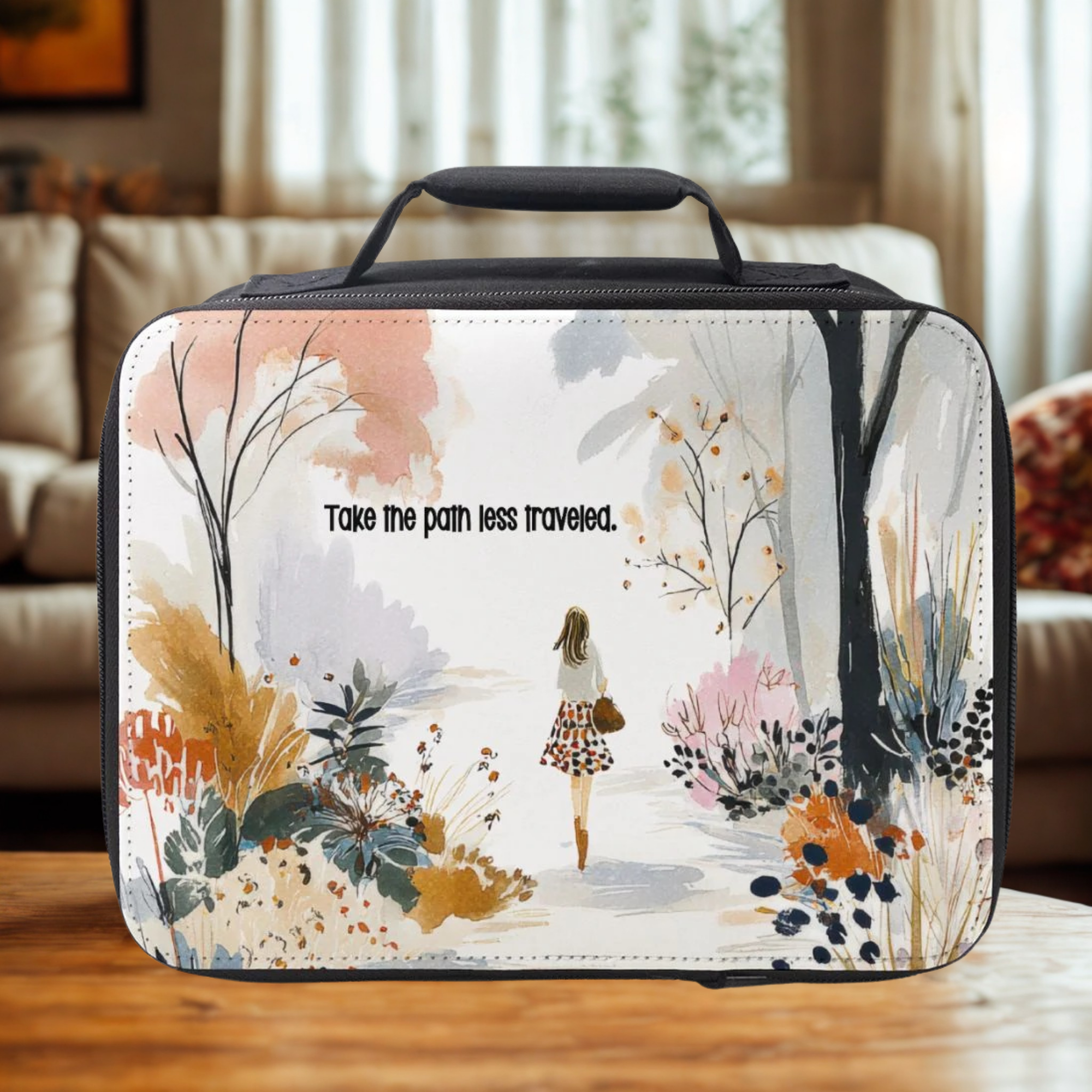 Travel bag with artistic design and text 'Take the path less traveled' on a wooden surface.