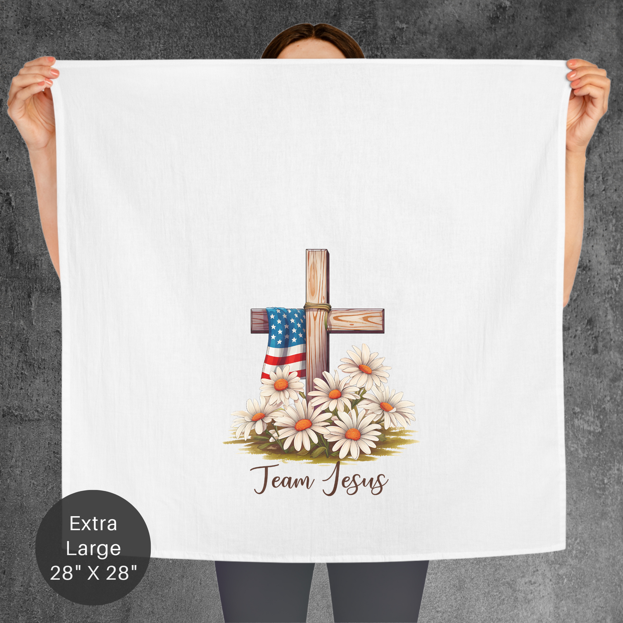 Person holding a large white towel with a cross and American flag design, labeled 'Team Jesus'.