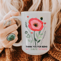 Person holding a 15oz mug with floral design and text 'Thank you for being my safe space' on a textured fabric background.