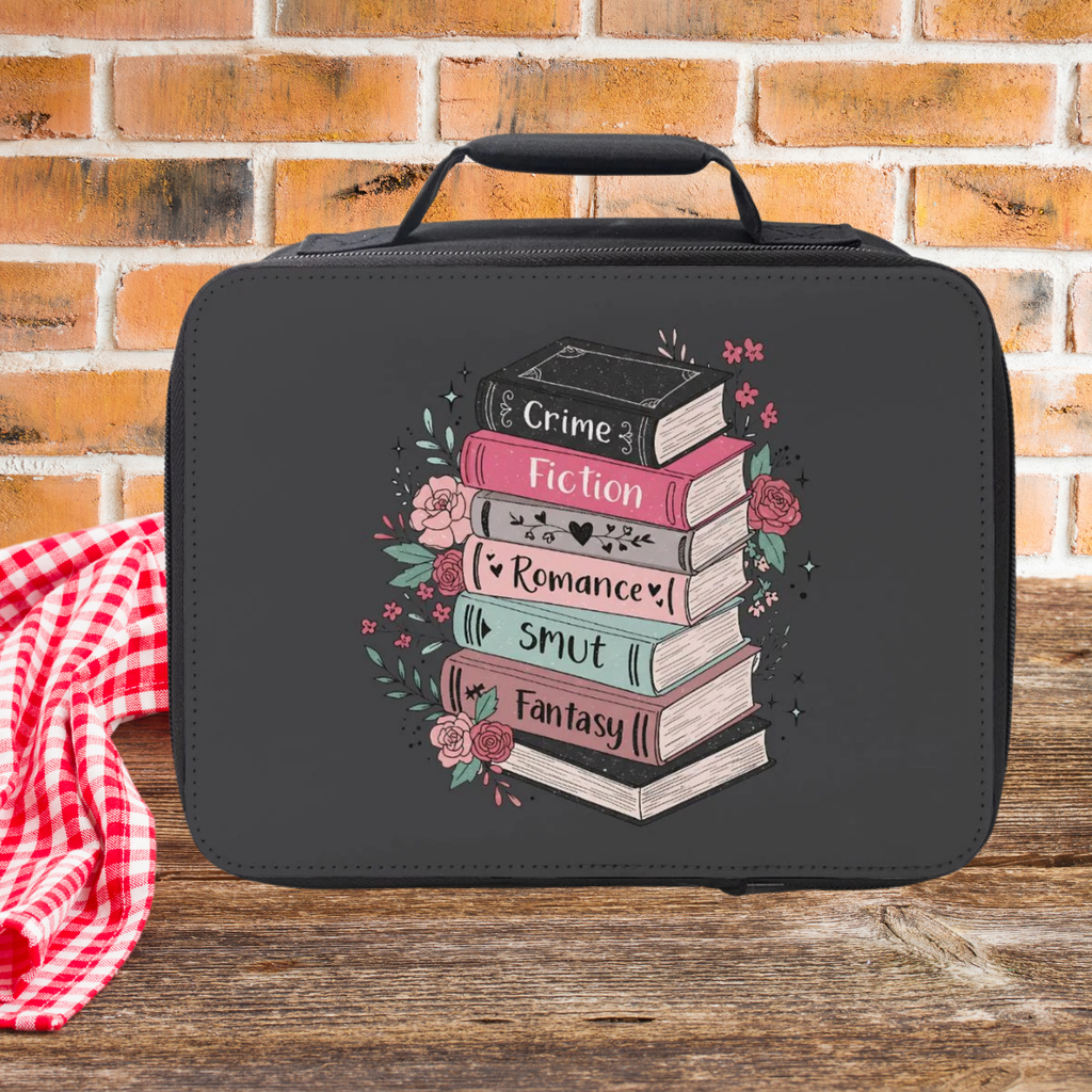 Black lunch bag with book design and text on a wooden picnic table with a brick wall background