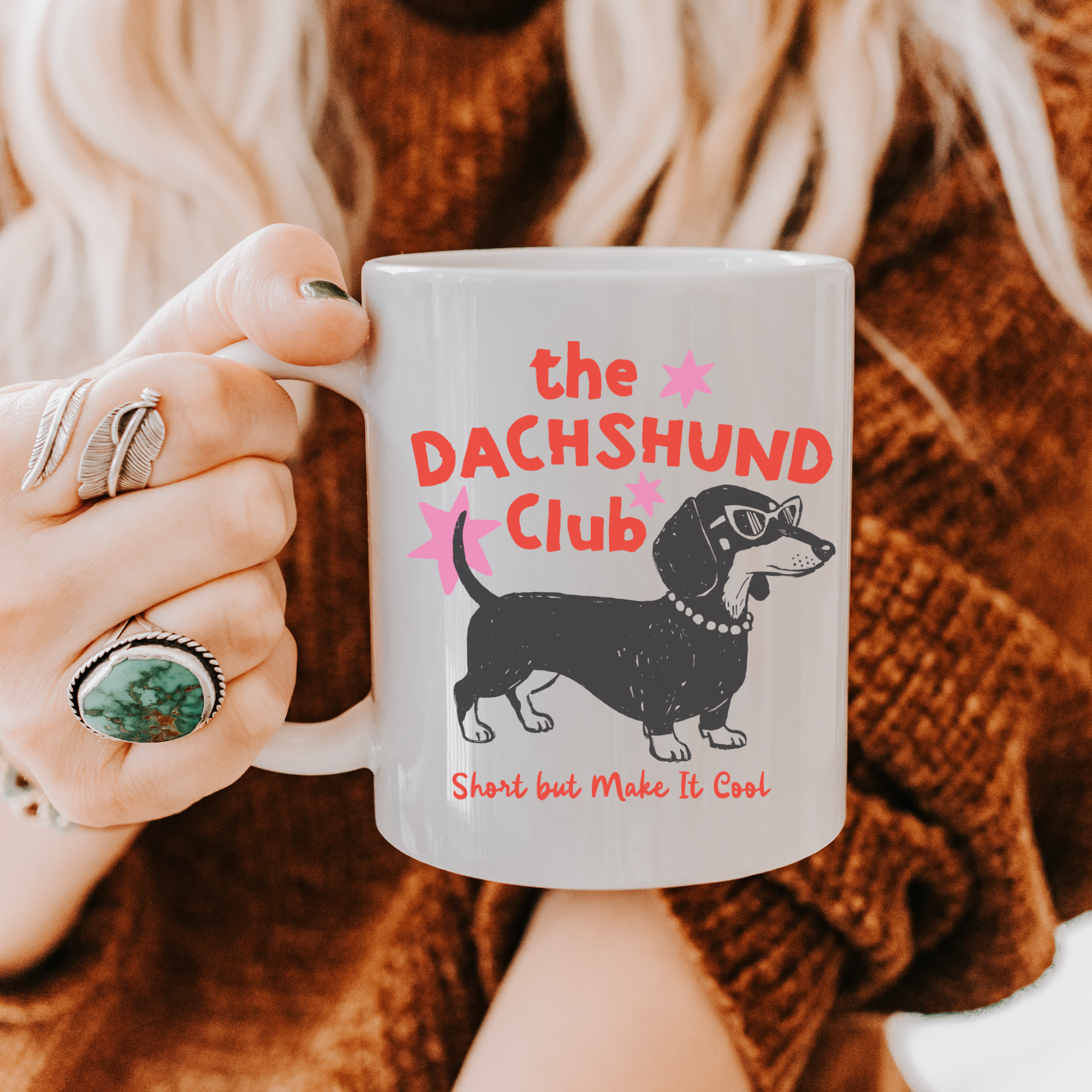 Person holding an 11oz mug with 'the DACHSHUND Club' design, featuring a dachshund dog illustration.