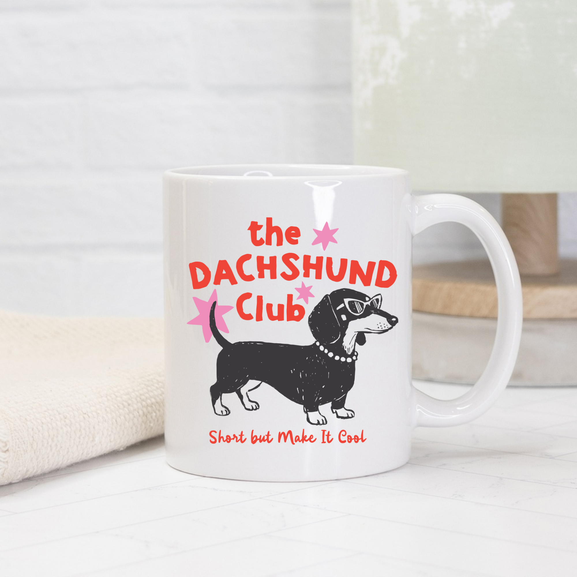 White 11oz. mug with dachshund illustration and text on a light background