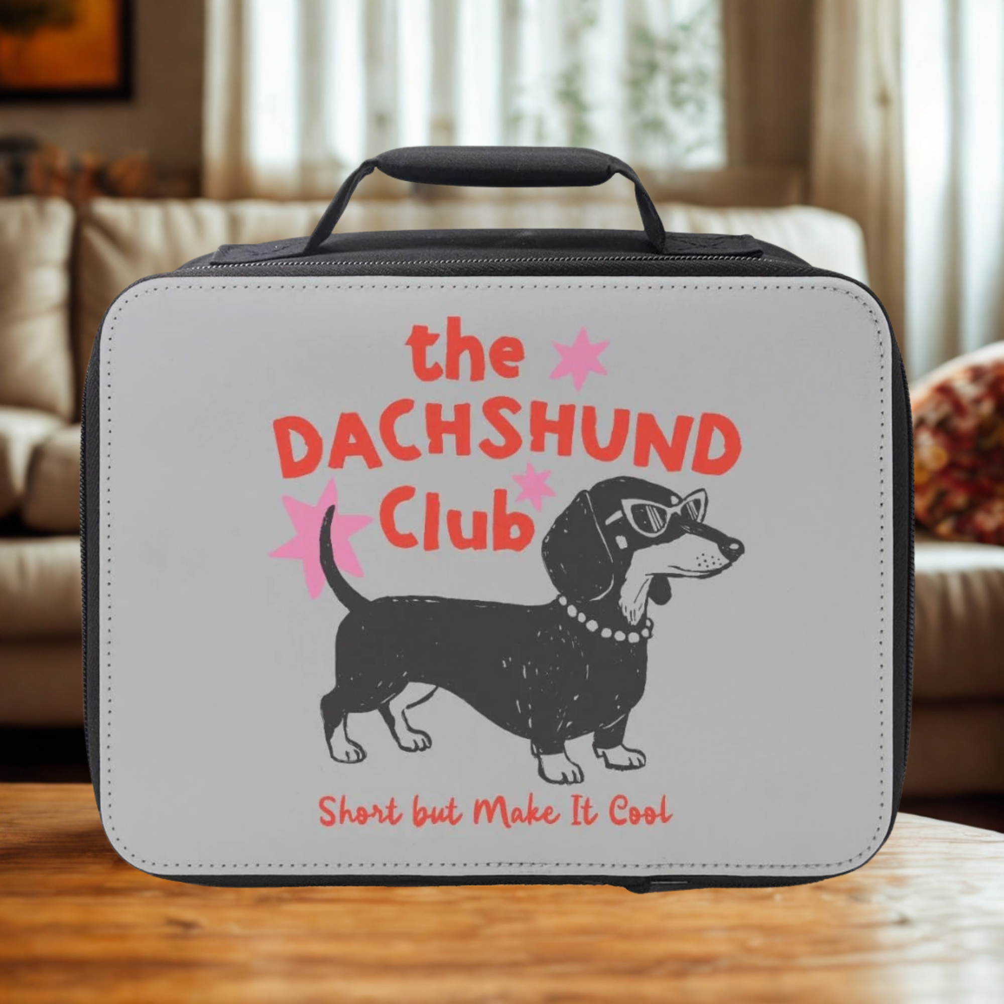 Lunch bag with Dachshund design and text on a wooden living room table 
