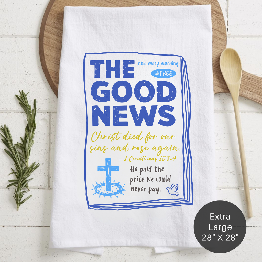 White tea towel with blue and yellow text and cross graphic on a wooden surface.