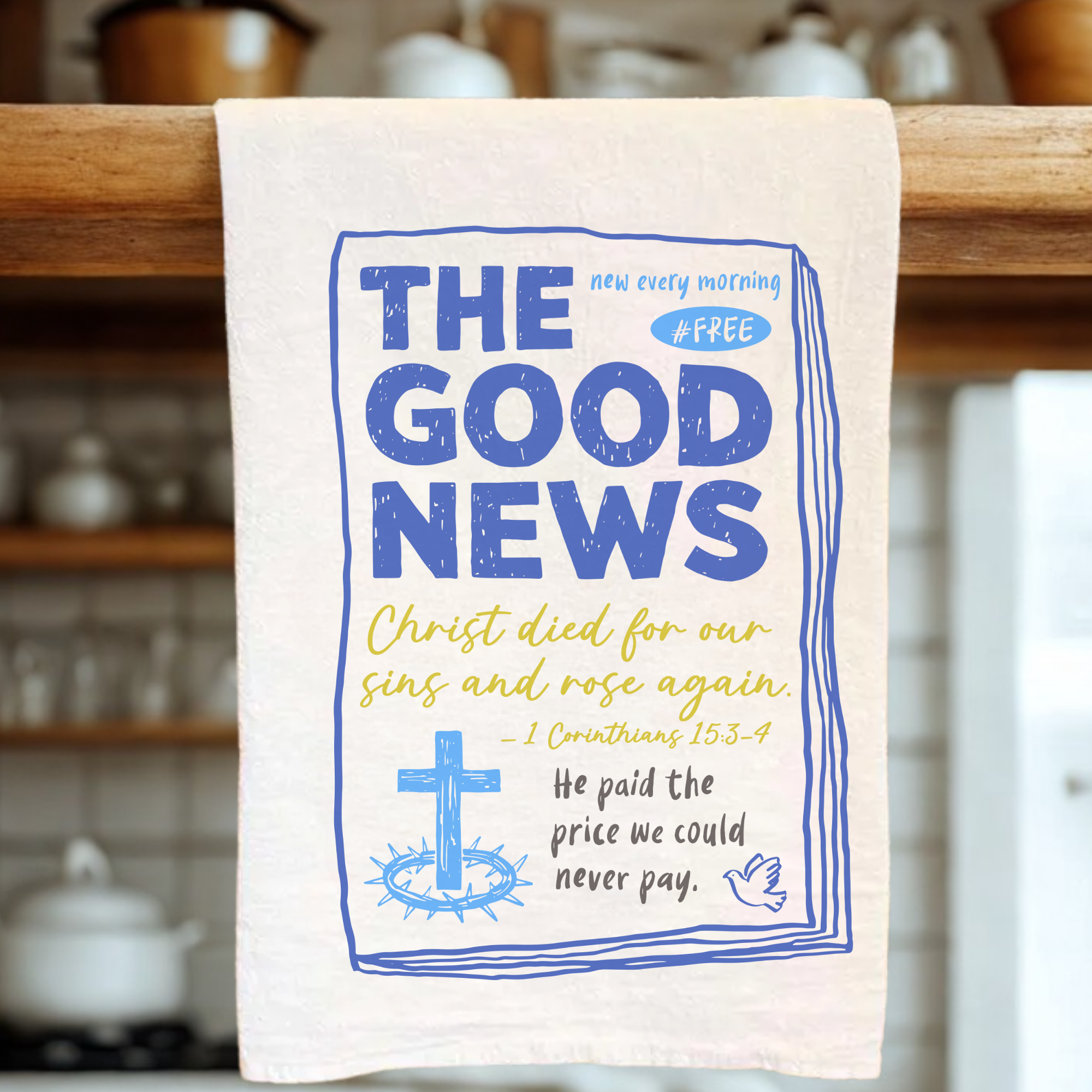 White tea towel with blue and yellow text and graphics on a wooden rack.
