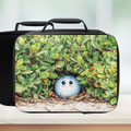 Black lunch bag with Golf ball with a face design on a light background