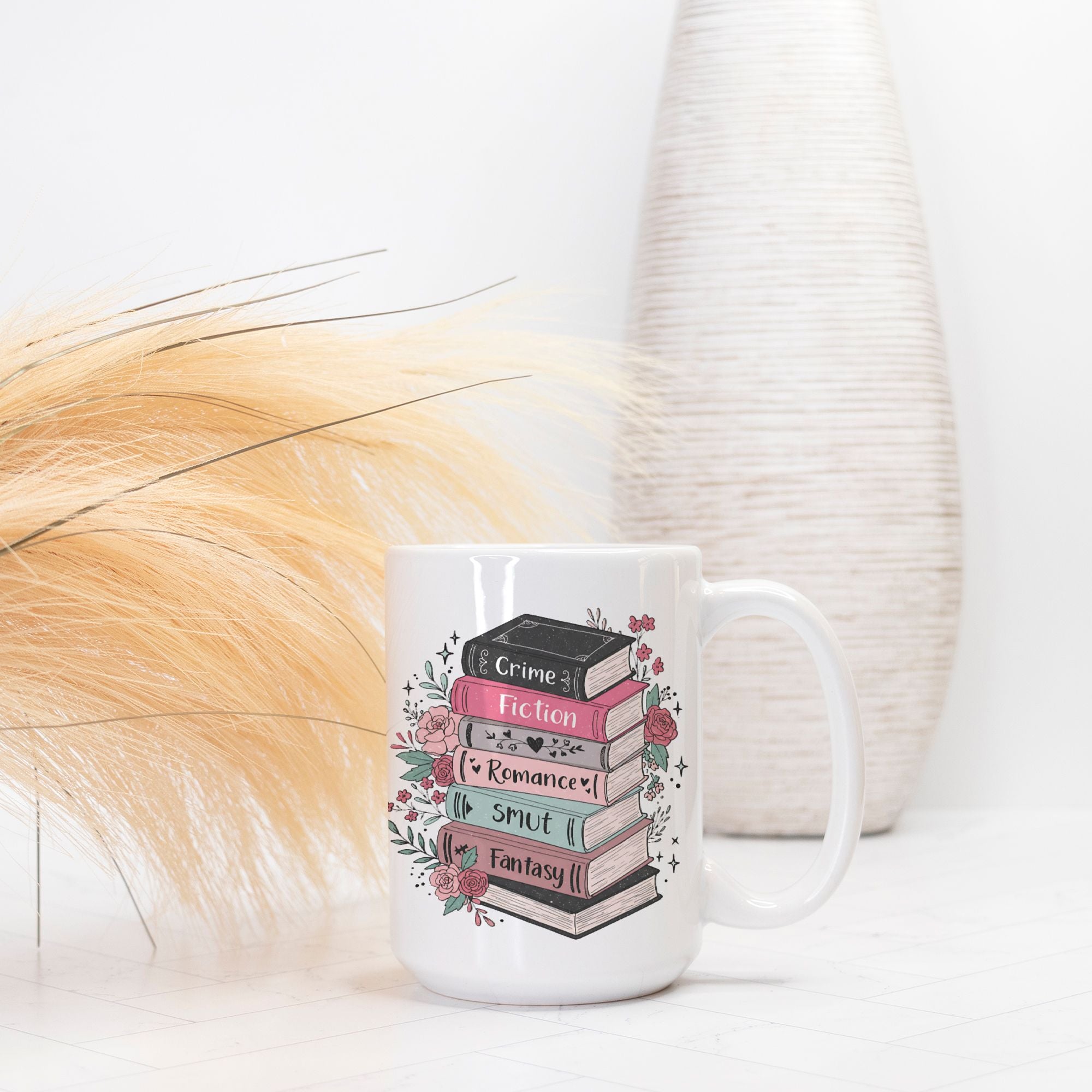 White mug with book design and text on a white surface with decorative elements