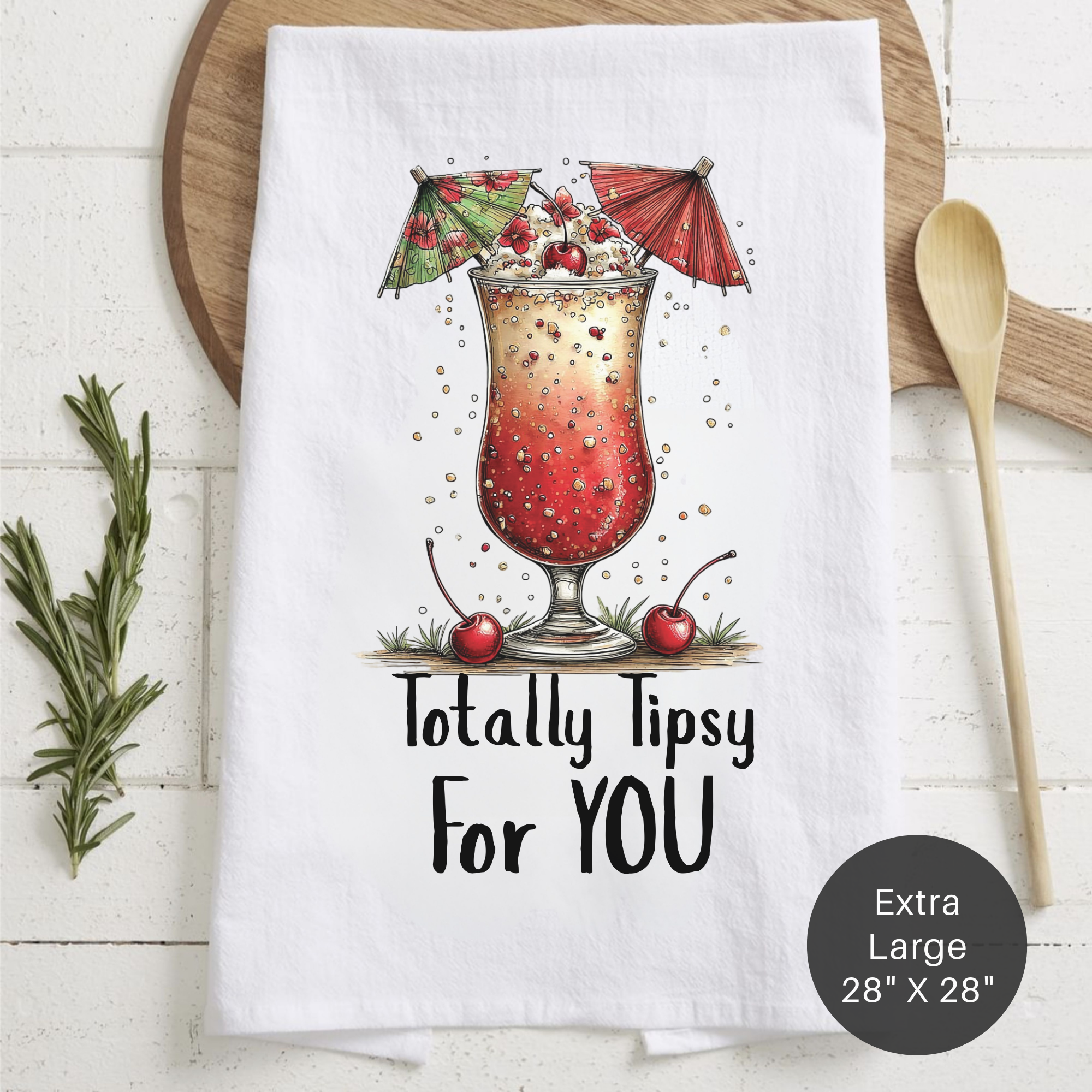 Tea towel with cocktail graphic and text 'Totally Tipsy For YOU' on a wooden board.