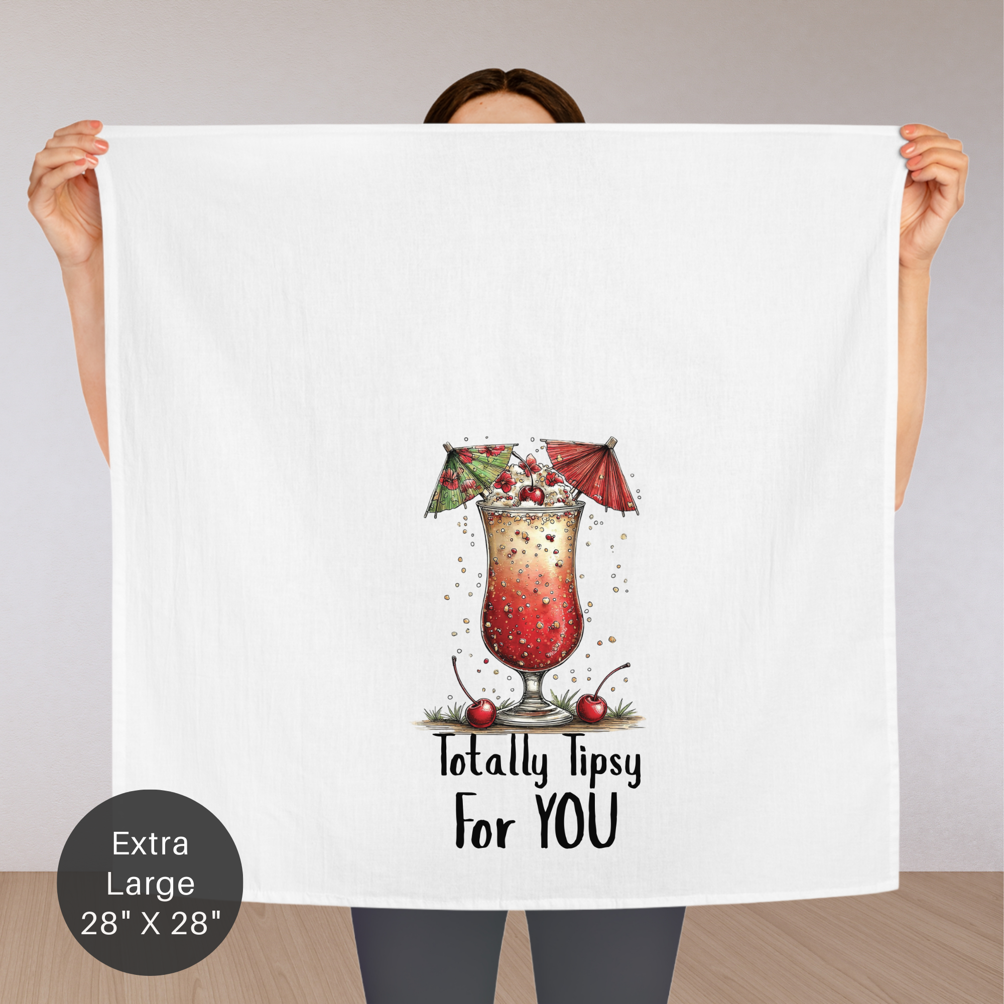 Person holding a large towel with a cocktail graphic and text on a plain background