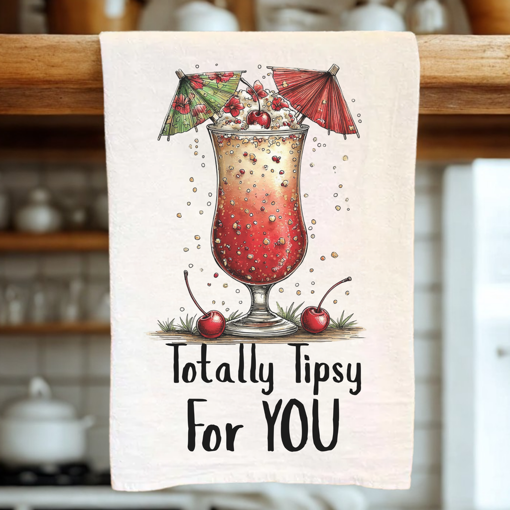 Tea towel with a cocktail illustration and text 'Totally Tipsy For YOU' on a wooden rack.