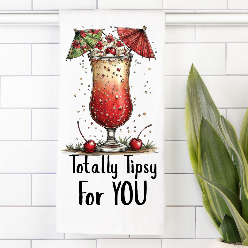 Tea Towel with Illustration of a cocktail with umbrellas, cherries, and text 'Totally Tipsy For YOU' on a white tiled wall background.