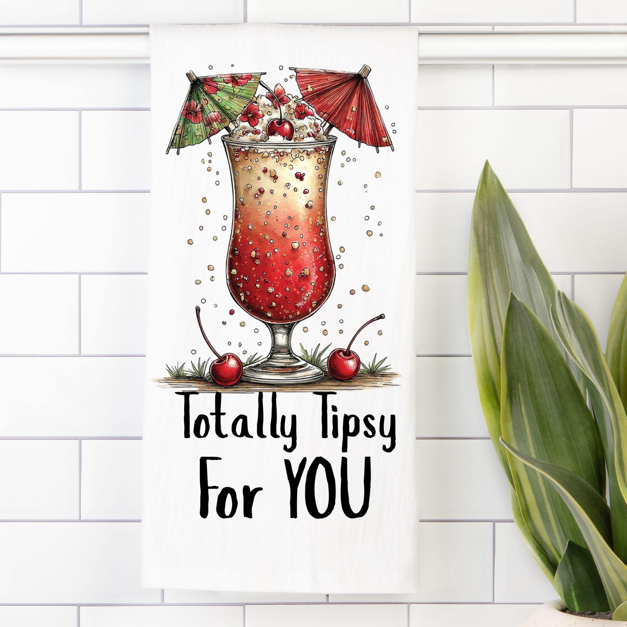 Tea Towel with Illustration of a cocktail with umbrellas, cherries, and text 'Totally Tipsy For YOU' on a white tiled wall background.