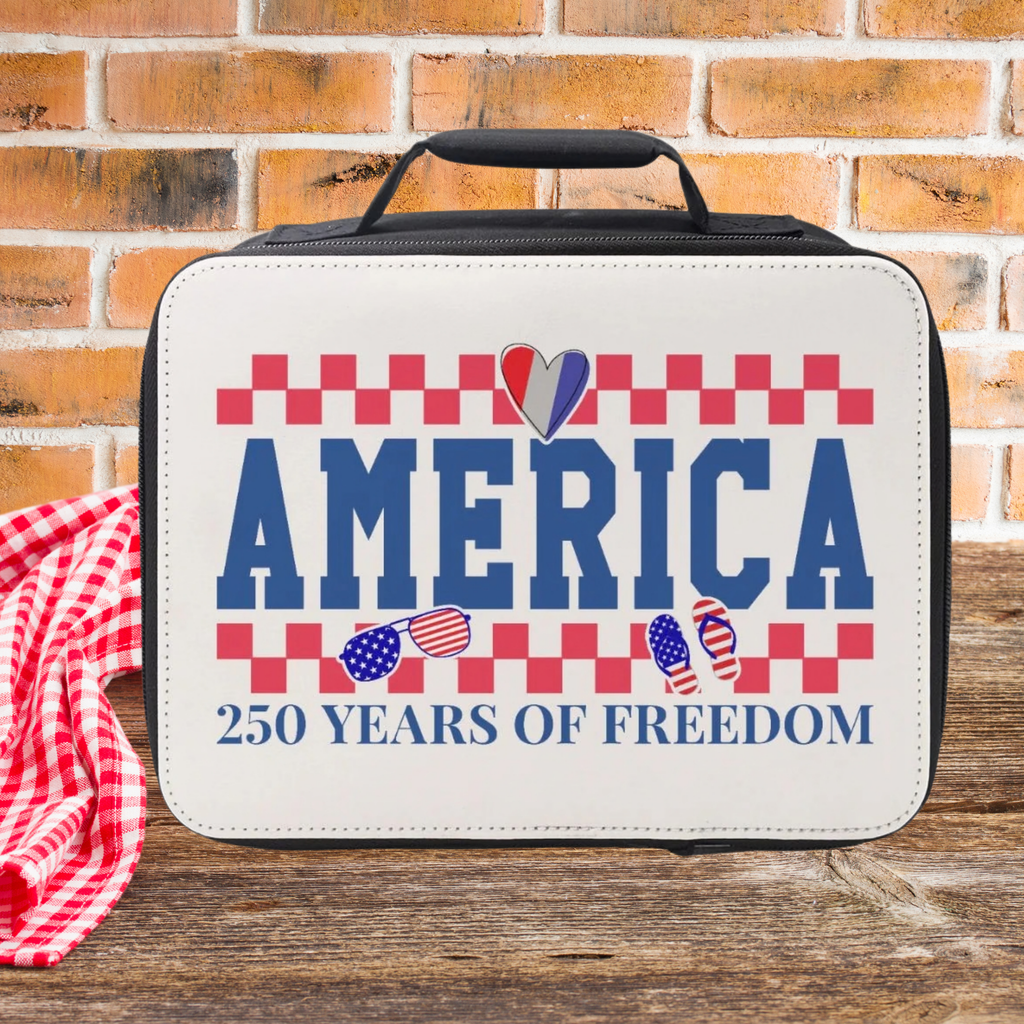 Lunch bag with 'America 250 Years of Freedom' text on a wooden picnic table with a brick wall background