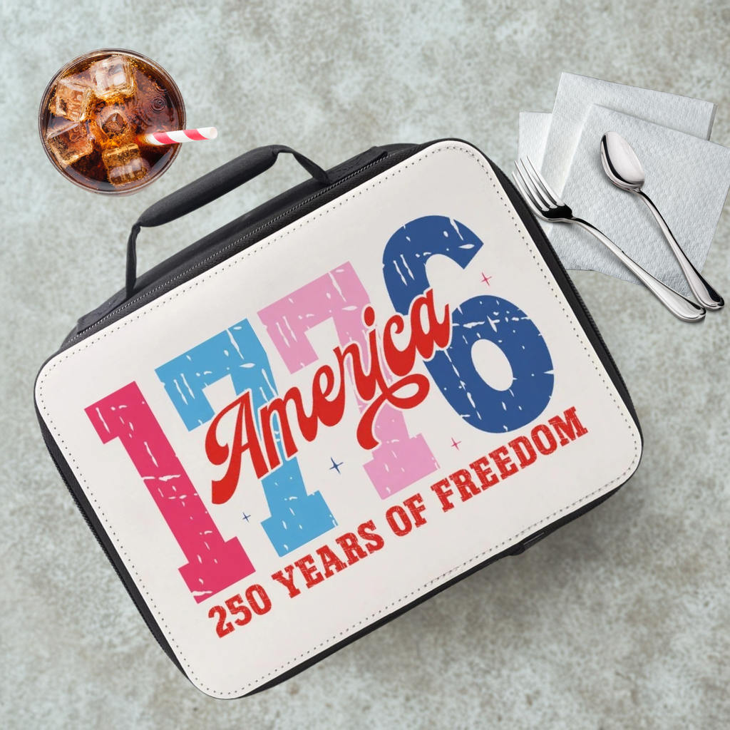 Lunch bag celebrating America's 250 years of freedom on a cafeteria table with a drink and utensils.