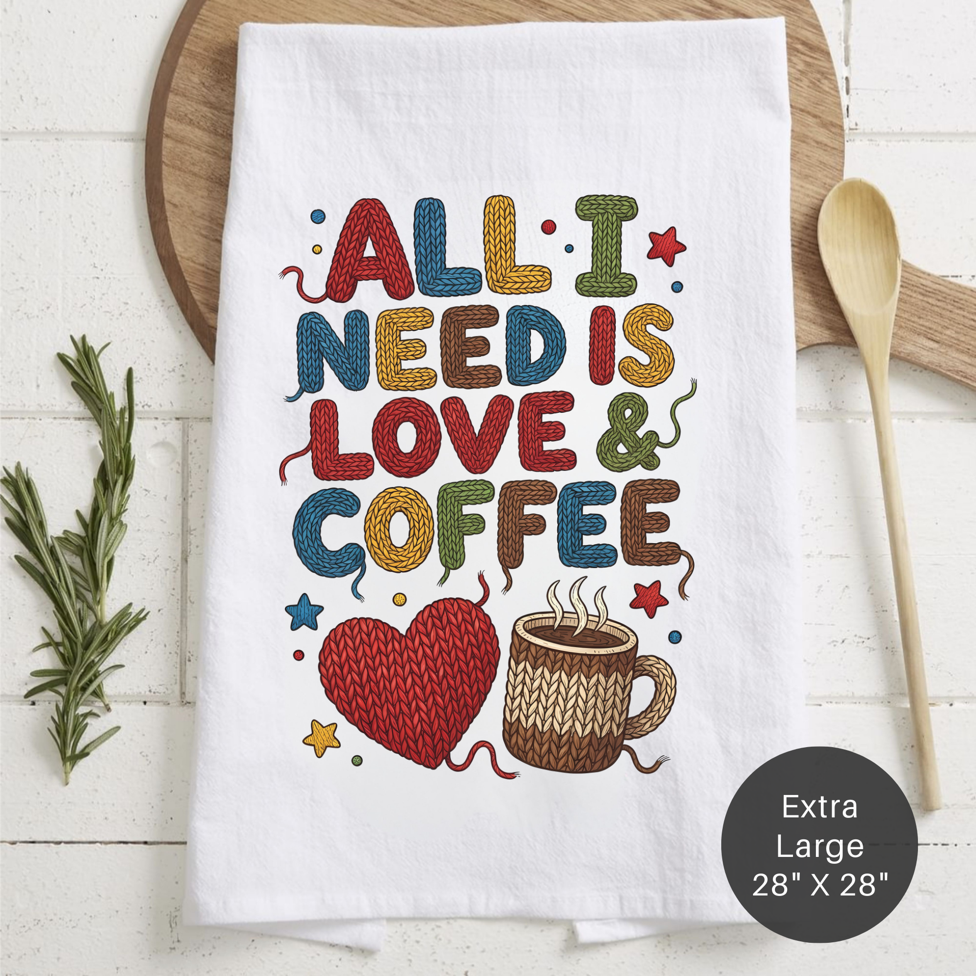White tea towel with colorful text 'All I Need is Love & Coffee' on a wooden surface.