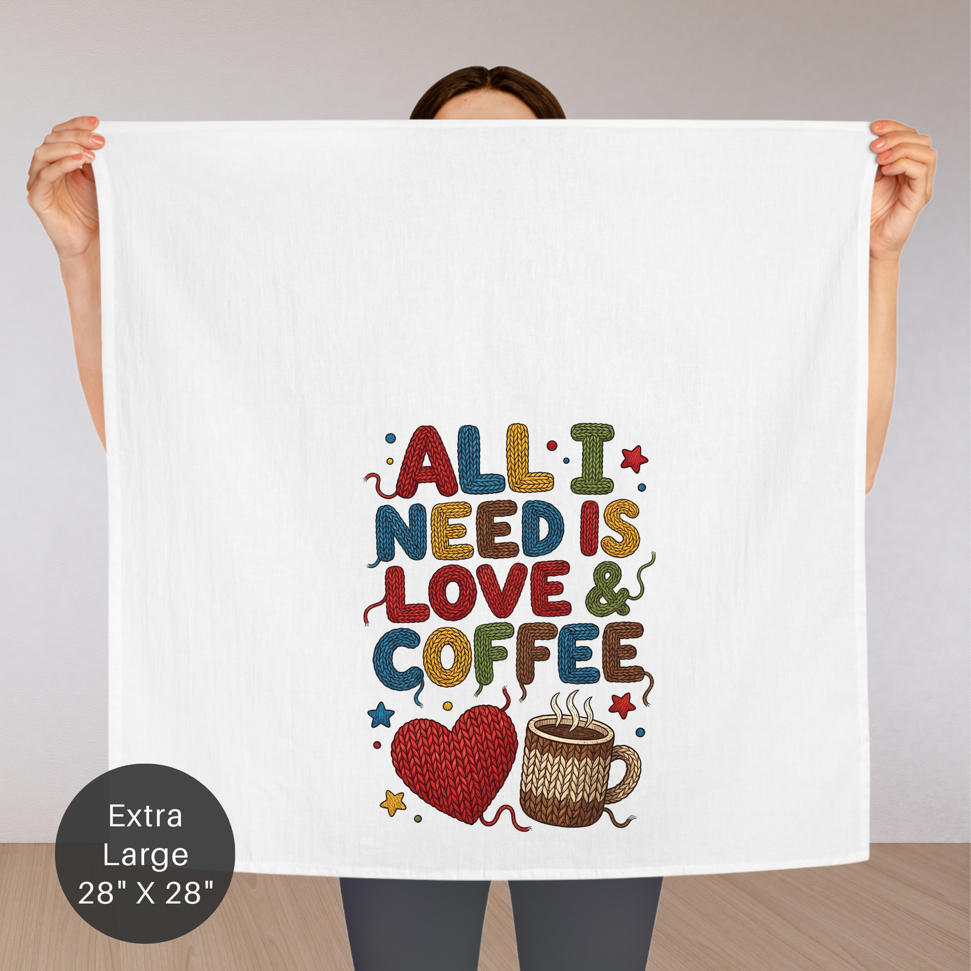 Person holding an extra large tea towel with 'All I Need is Love & Coffee' text and graphics.