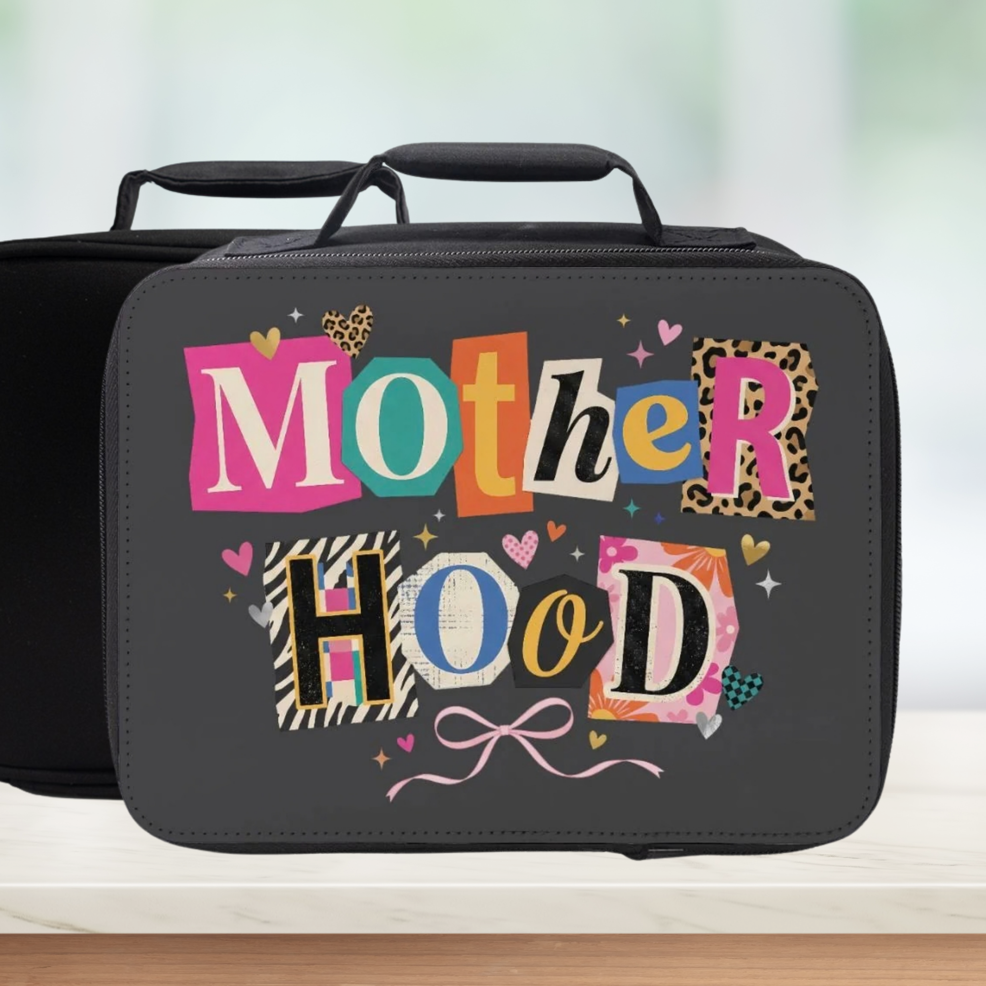 Black lunch bag with colorful 'Mother Hood' text on a light background