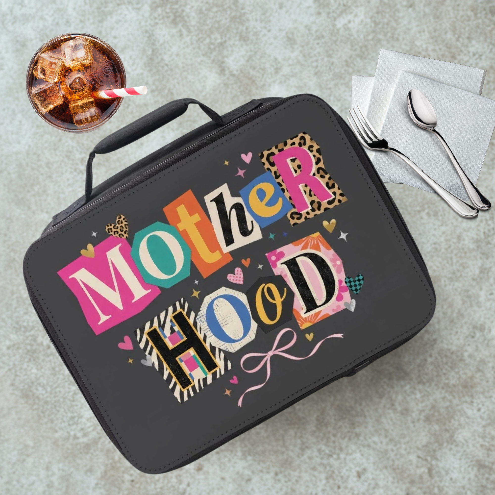 Lunch bag with 'Mother Hood' design on a cafeteria table with a drink and utensils.