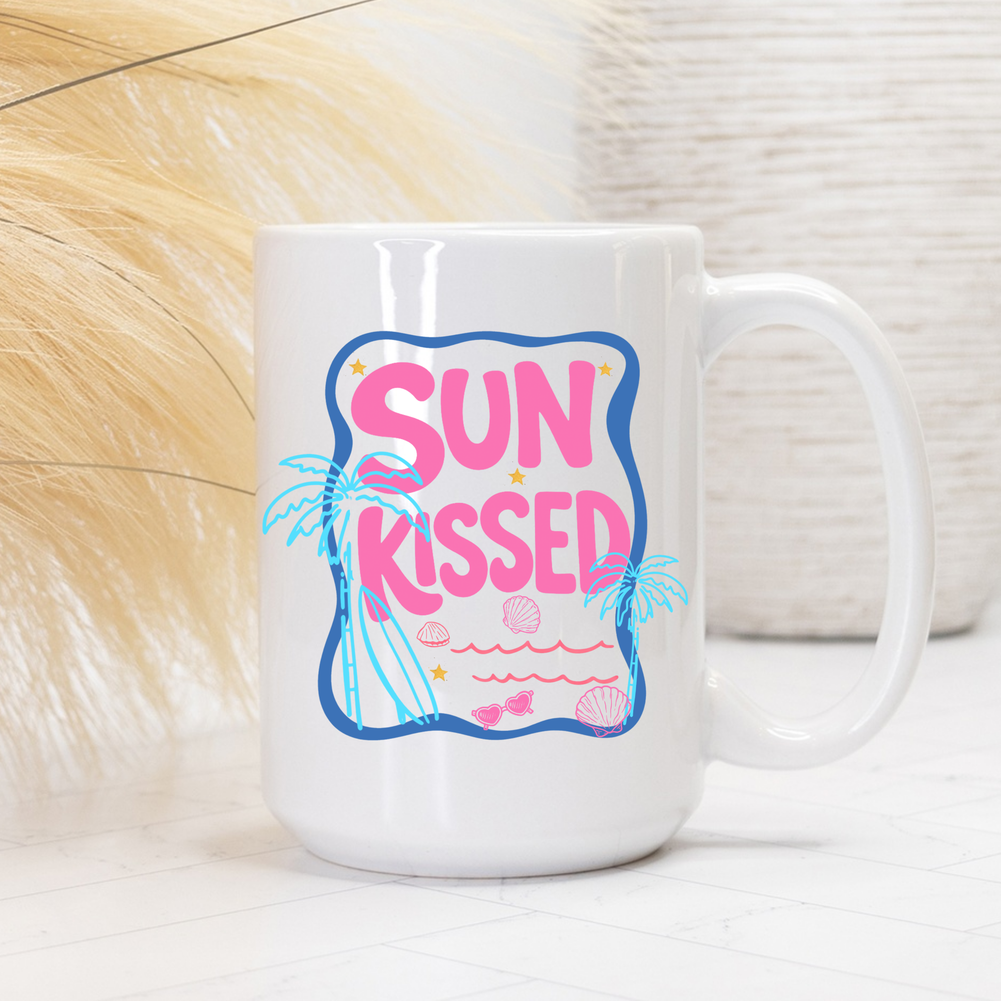 White 15oz. mug with 'Sun Kissed' design featuring pink text and beach elements on a light background.