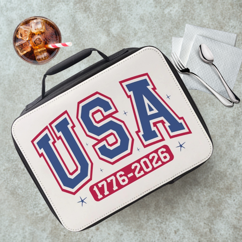 Lunch bag with 'USA 1776-2026' text on a cafeteria table with a drink and utensils.