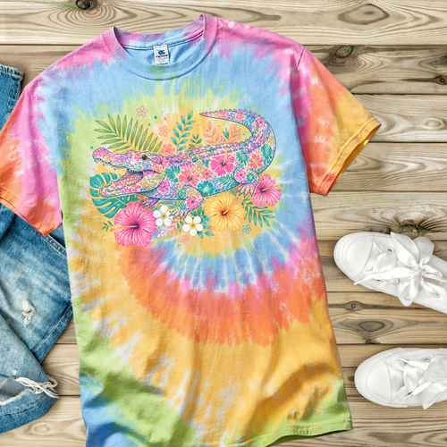 Colorful tie-dye t-shirt with an alligator design on a wooden surface.