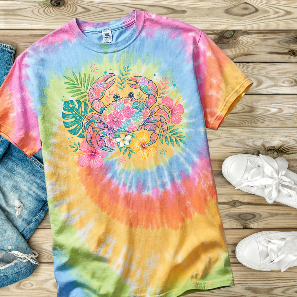 Colorful tie-dye t-shirt with a floral crab design on a wooden surface.