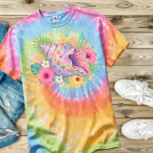 Colorful tie-dye t-shirt with a sea shell and floral design on a wooden surface.
