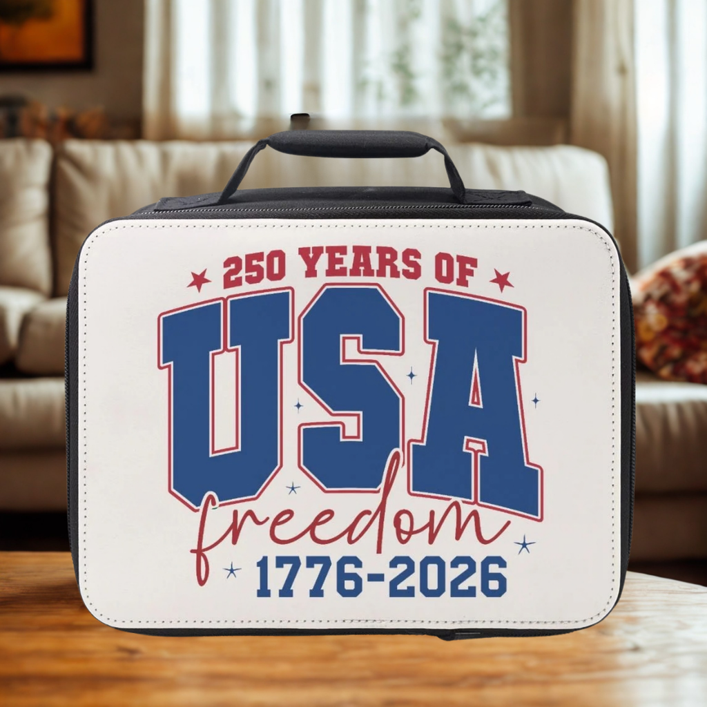 Lunch bag with '250 Years of USA Freedom 1776-2026' text on a wooden coffee table in a living room.