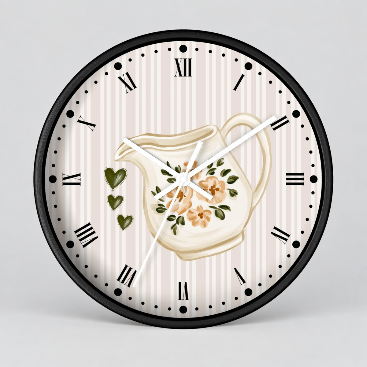 Round wall clock with a black frame, cream and beige vertical stripes, Roman numerals, black hour markers, white hands, a central cream pitcher illustration with floral details, and three green hearts on the left side, shown against a light gray background.