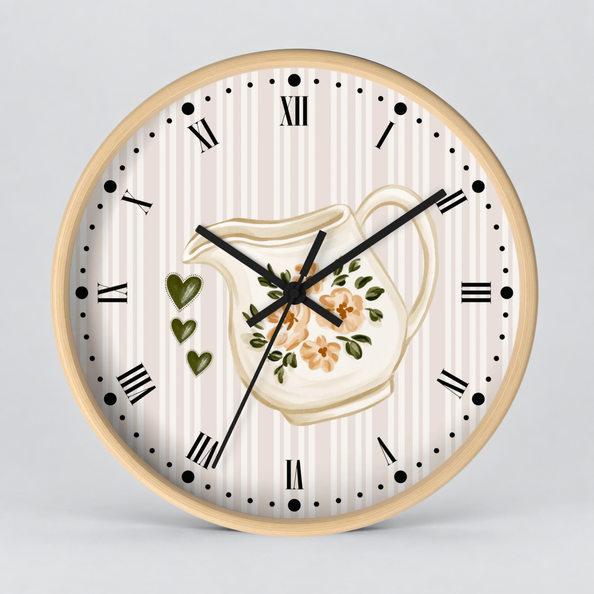 Round wall clock with a light wood frame, featuring a cream and white vertically striped dial, black Roman numerals, black clock hands, and a central illustration of a floral cream pitcher with three green hearts.