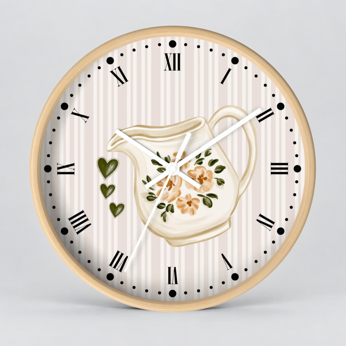 Round wall clock with a light wood frame, featuring a cream and beige vertically striped dial, black Roman numerals, white hands, a central floral pitcher illustration, and three green hearts on a light gray background.